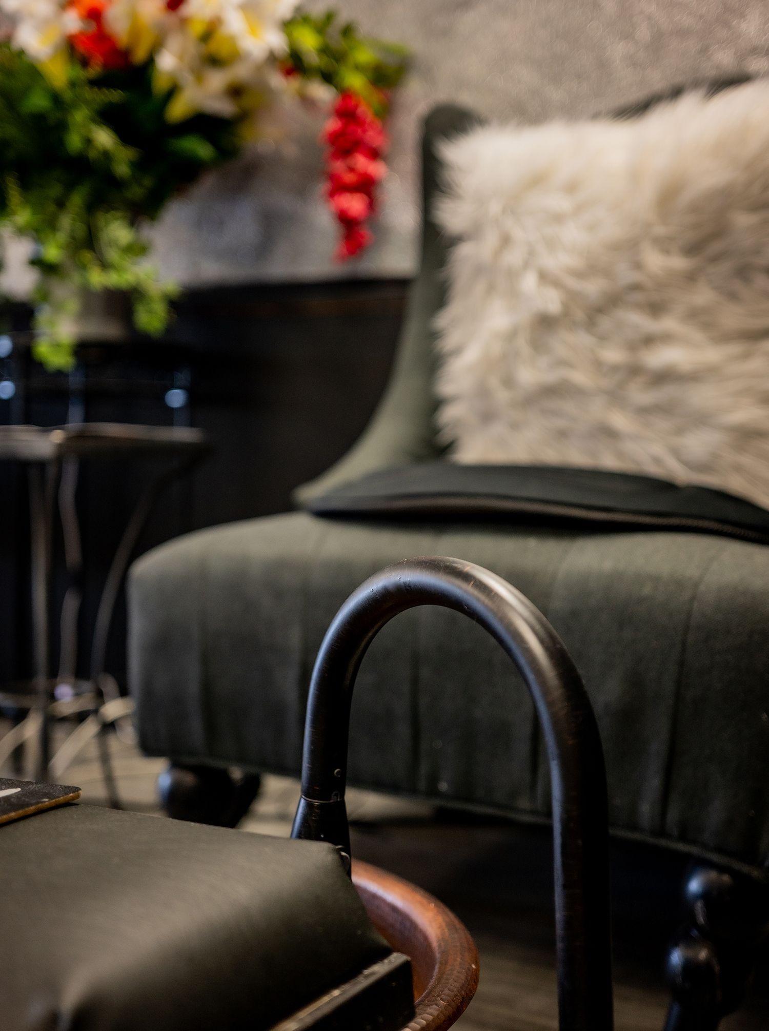 A chair with a pillow on it and a faucet next to it.