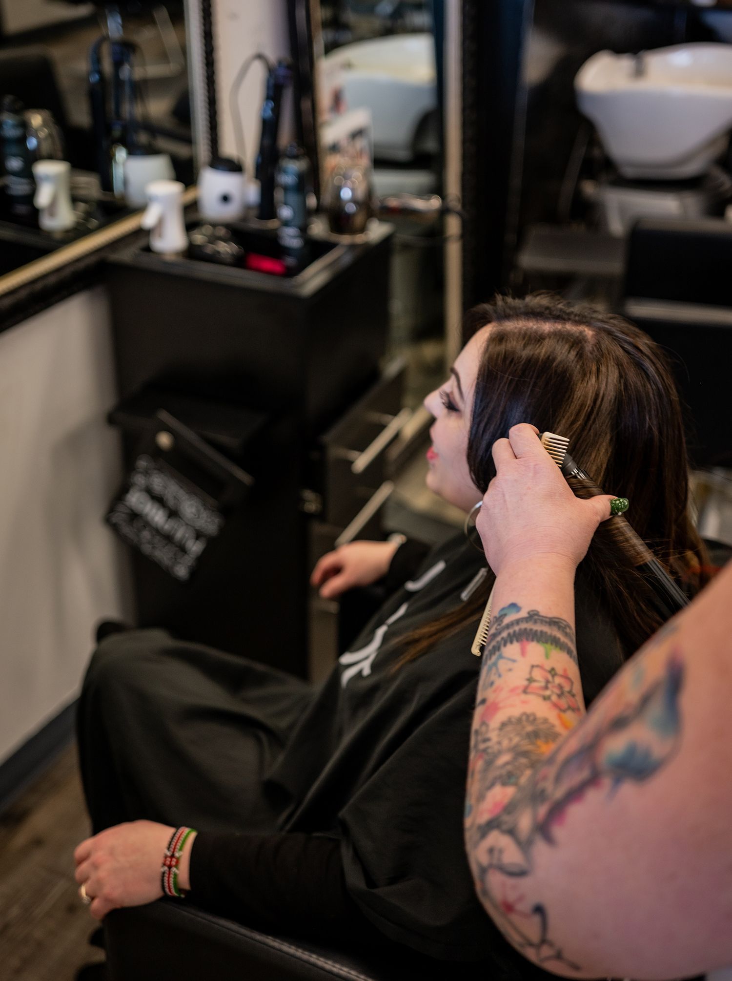 A woman is getting her hair cut by a man in a salon.