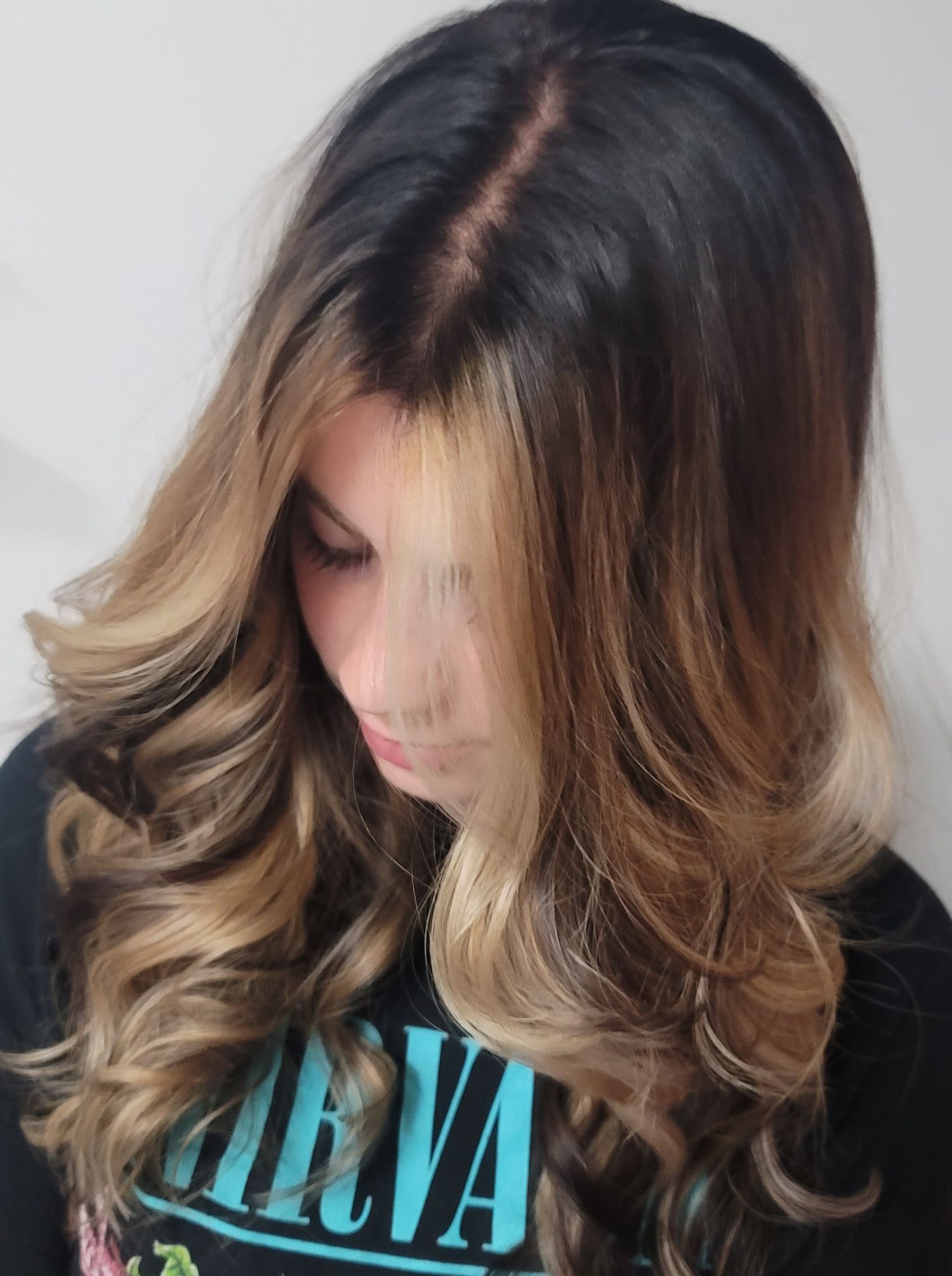 A woman with long hair is wearing a nirvana shirt