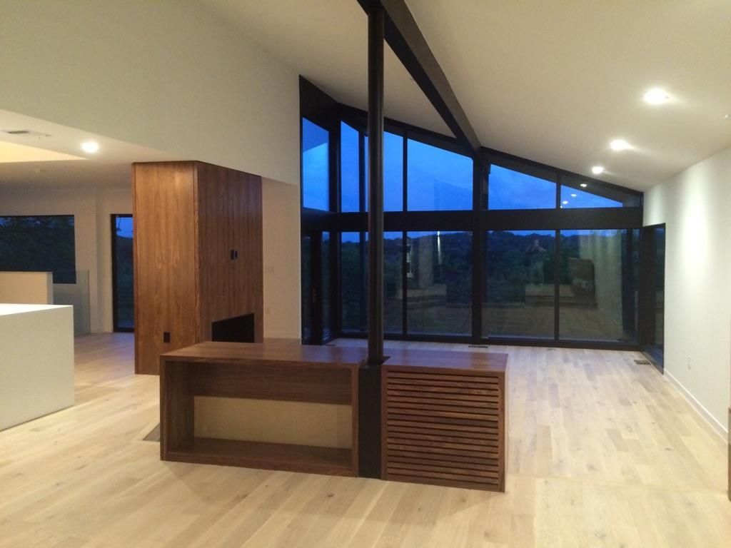 A living room with a lot of windows and a wooden table