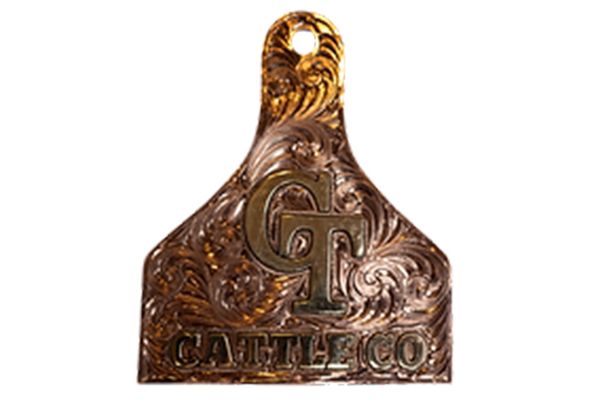 A close up of a cattle co. tag on a white background