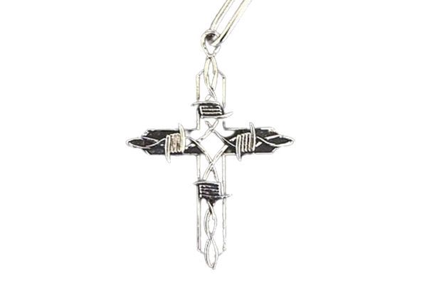 A close up of a cross pendant on a chain on a white background.