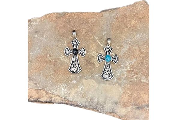 Two cross pendants are sitting on top of a piece of rock.