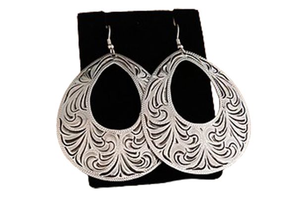 A pair of silver earrings are sitting on a black velvet display case.
