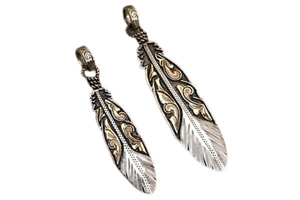 A pair of silver and gold feather pendants on a white background.