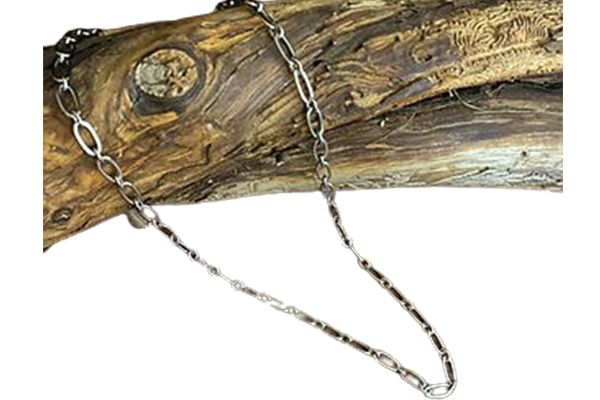 A necklace is sitting on top of a piece of wood.