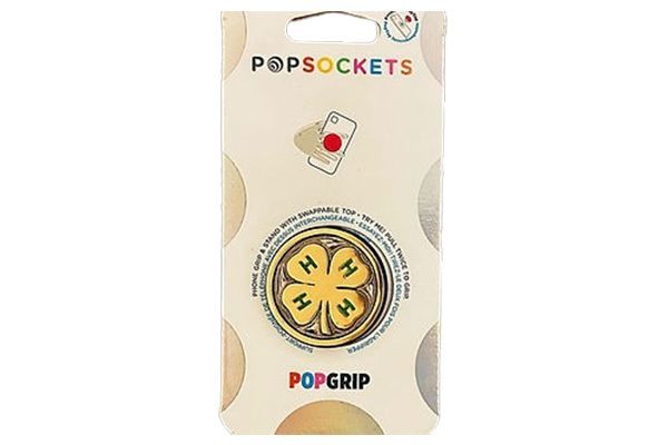 A popsocket with a four leaf clover on it is in a package.