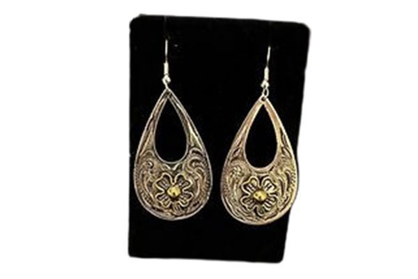 A pair of earrings are sitting on top of a black display case.