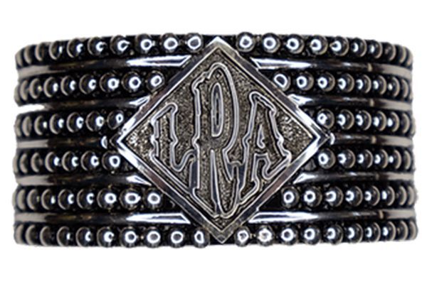 A bracelet with a monogram on it is stacked on top of each other.