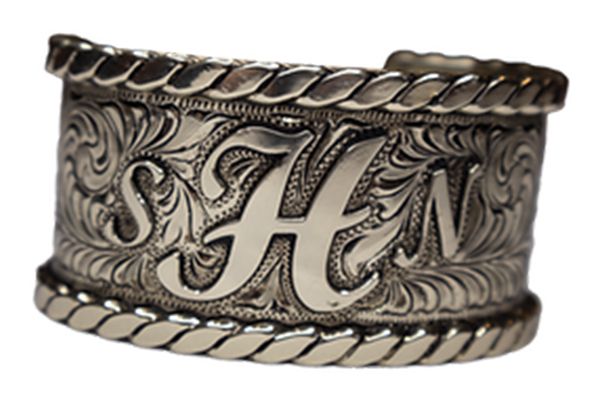 A silver bracelet with the letter h on it