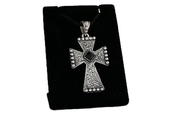 A cross necklace is sitting on a black velvet display case.