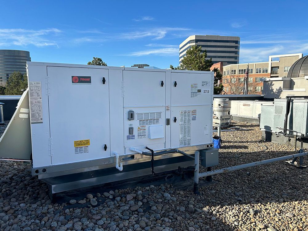 a large white machine is sitting on top of a rocky roof.