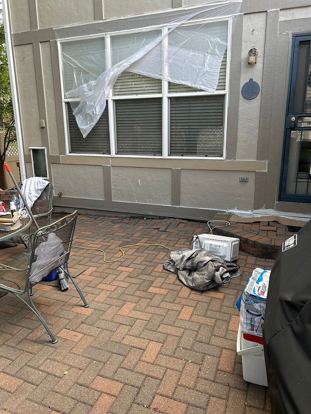 a mobile home with a broken window is sitting on a brick patio.