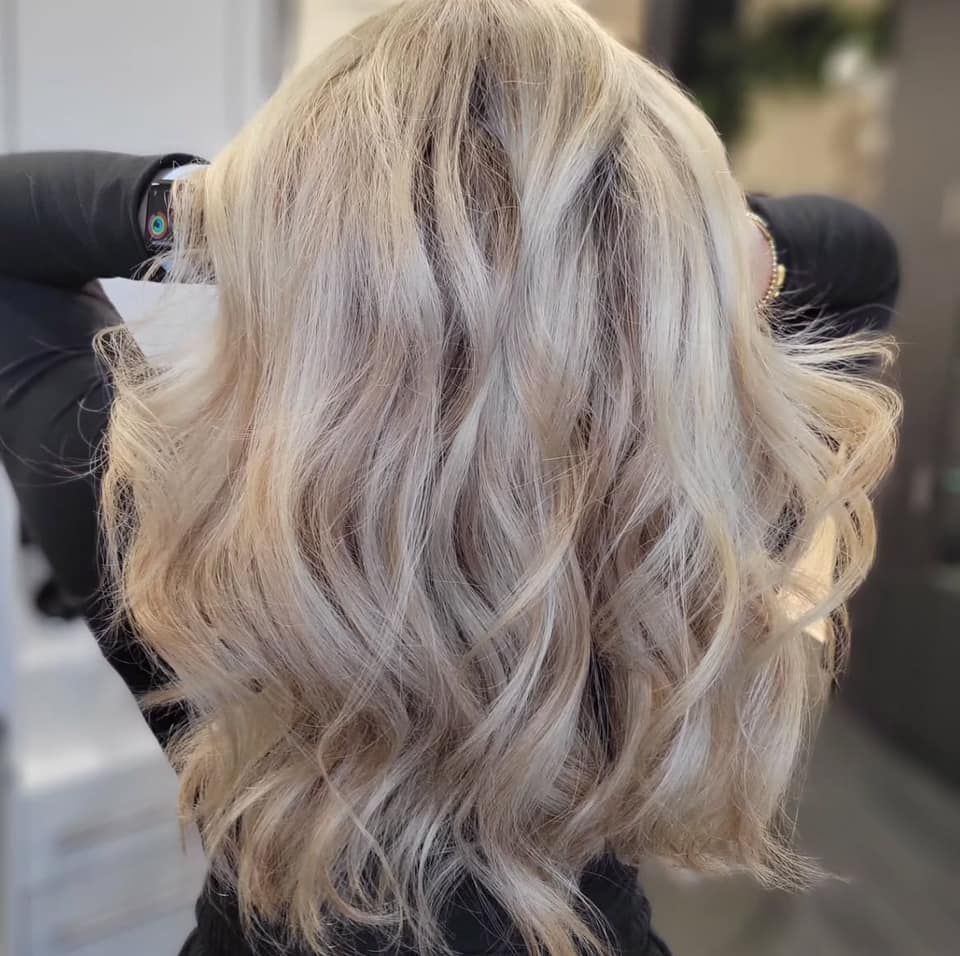 Blonde wavy hair, back view, styled, with light highlights.