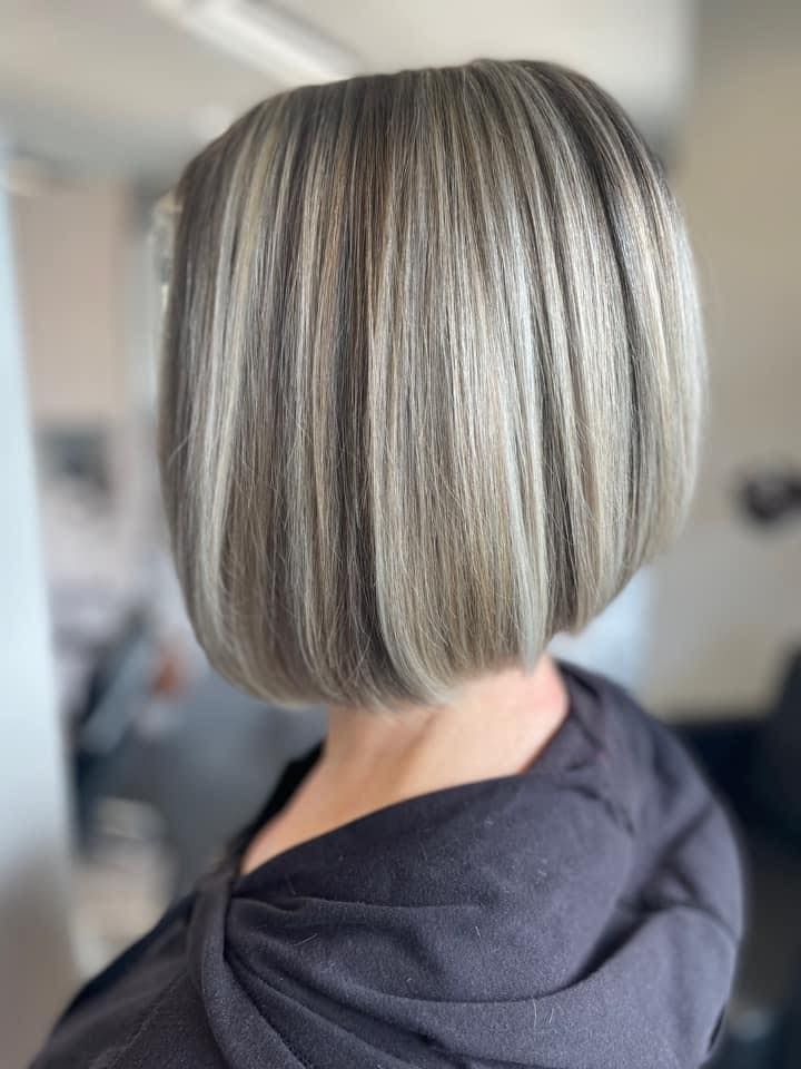 Blonde bob haircut with highlights, back view of a woman in a dark top.