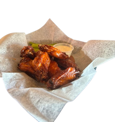 A basket of chicken wings with a side of dipping sauce