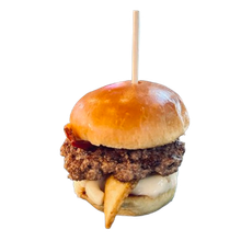 A small hamburger with a toothpick sticking out of it.