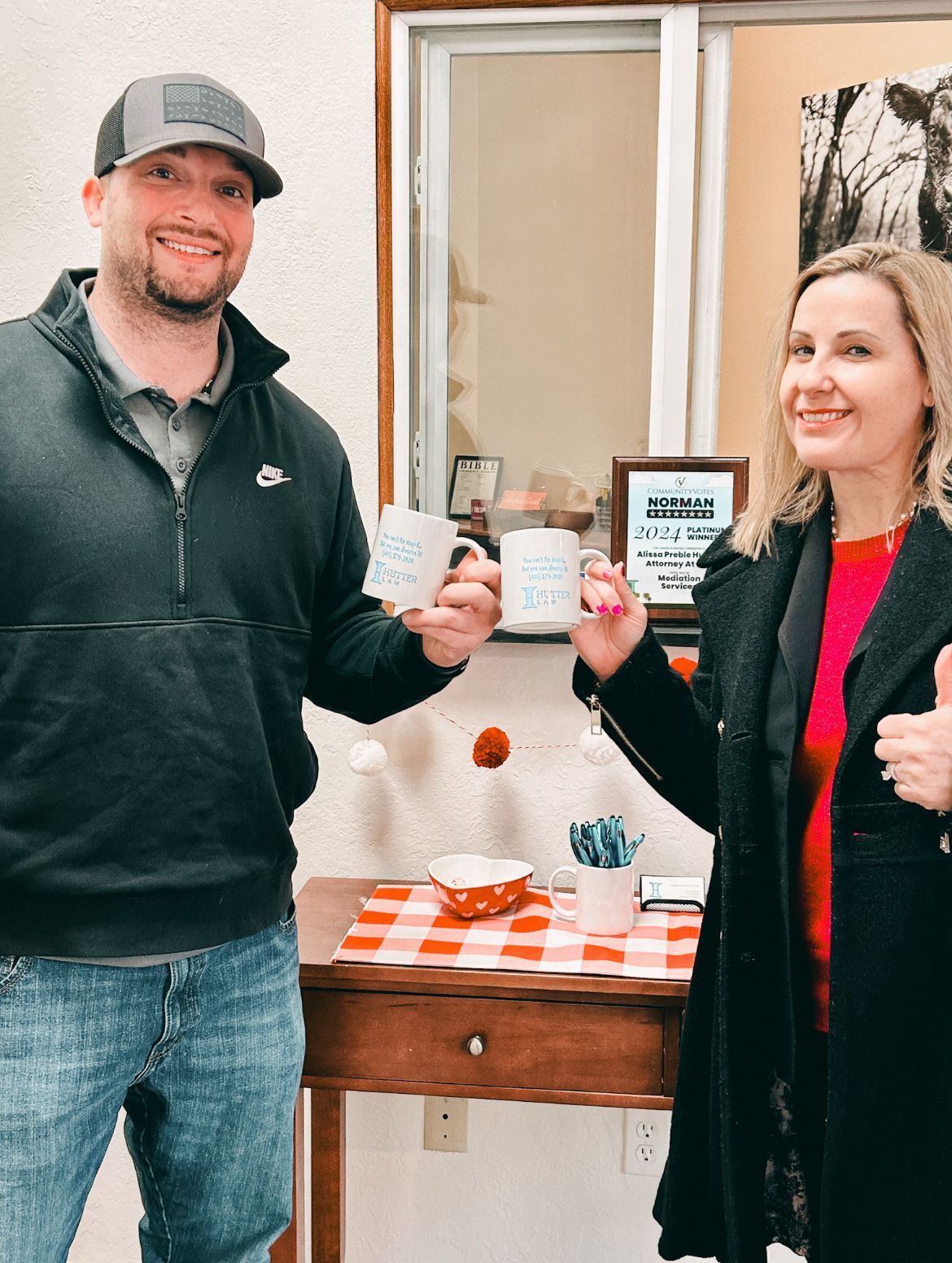 A man and a woman are standing next to each other holding coffee mugs.