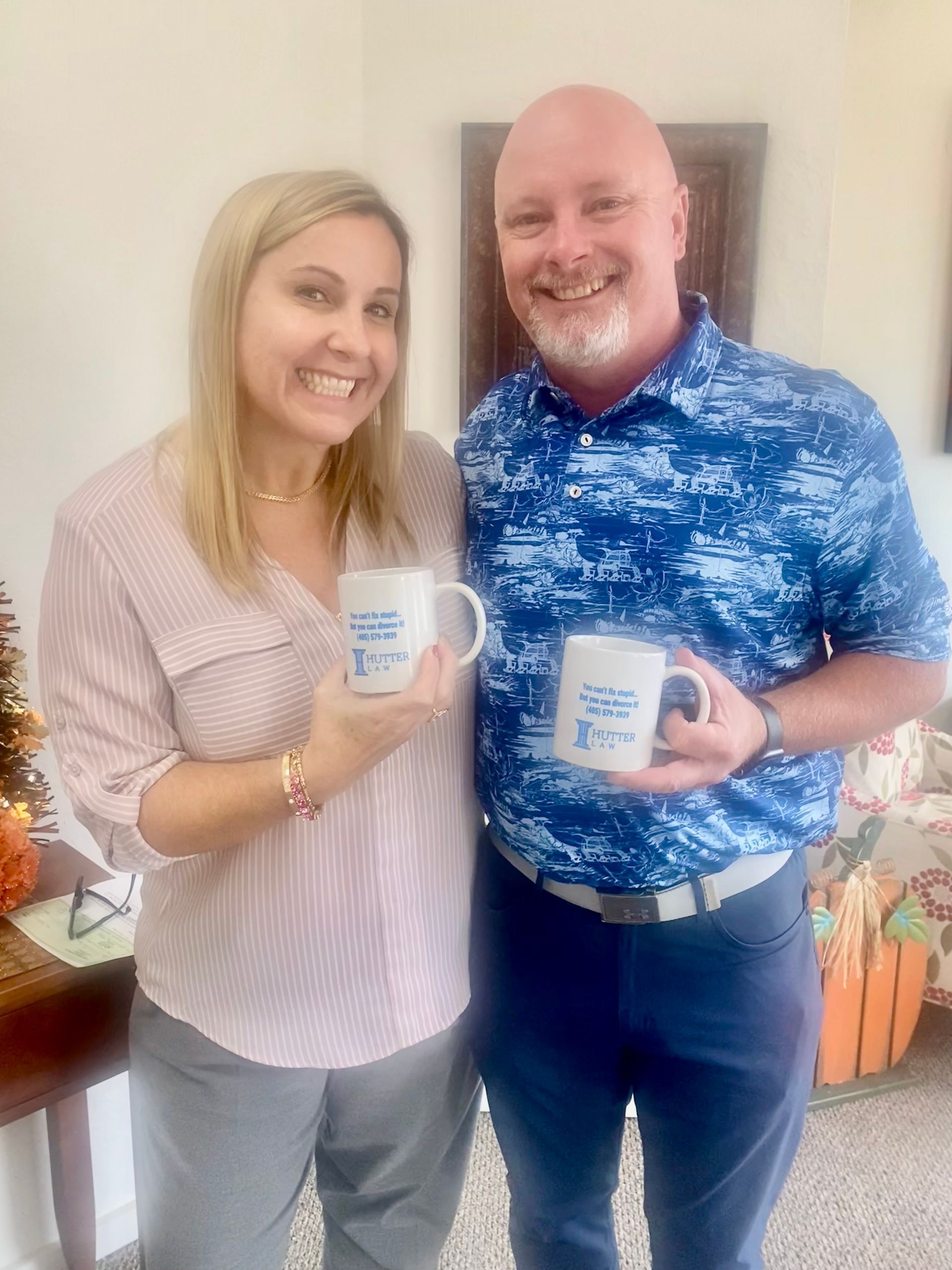 A man and a woman are standing next to each other holding coffee mugs.