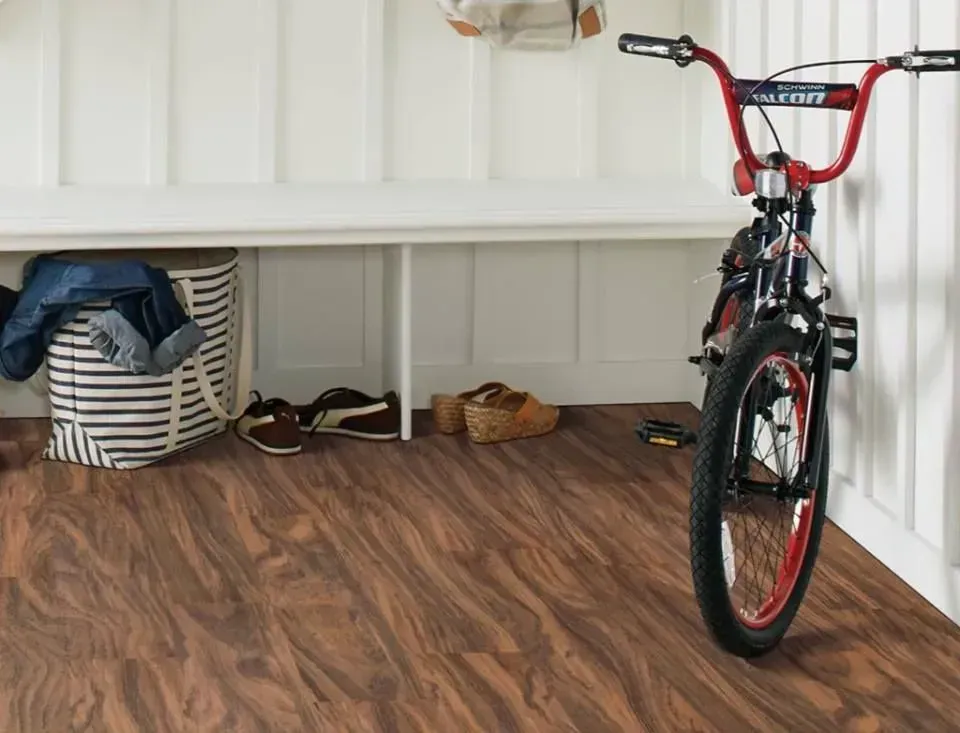 A bicycle is parked in a hallway next to a bench.