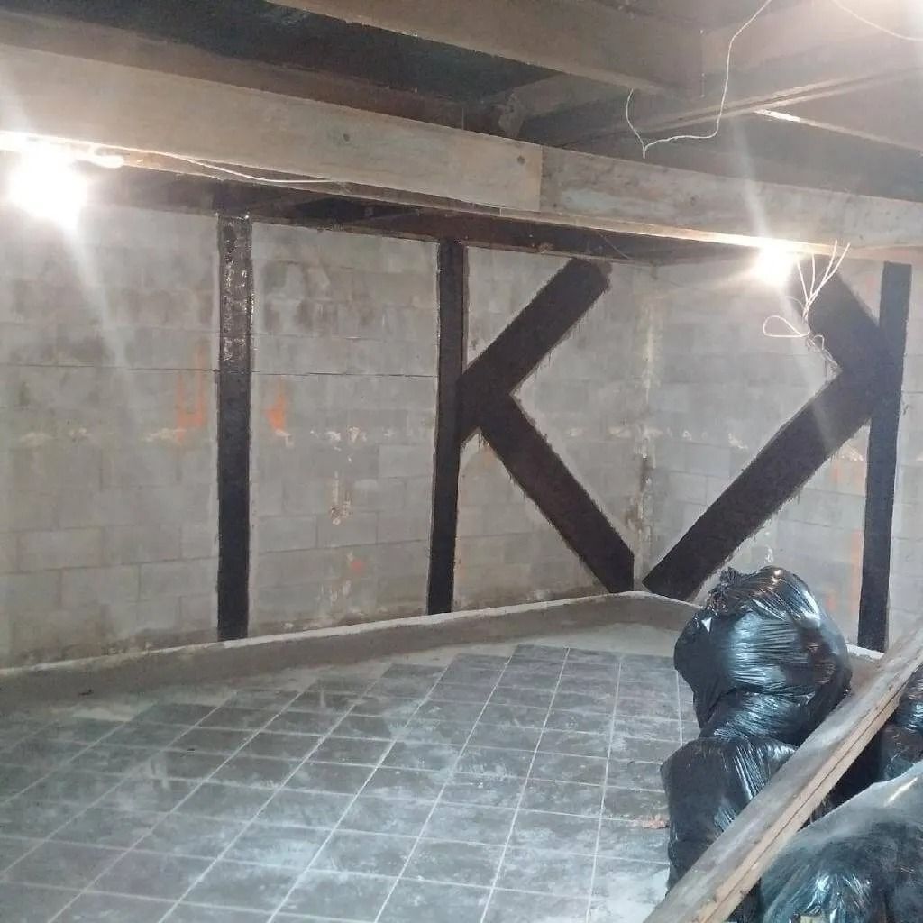 Basement wall with black supports. Concrete block wall with gray tile floor.