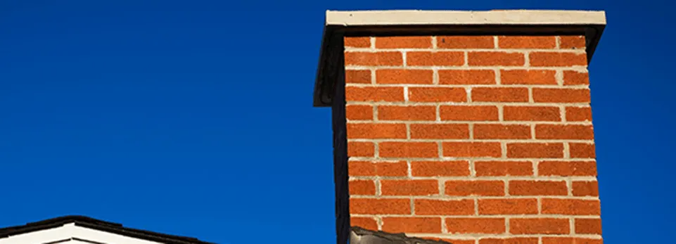 Brick chimney against a deep blue sky.