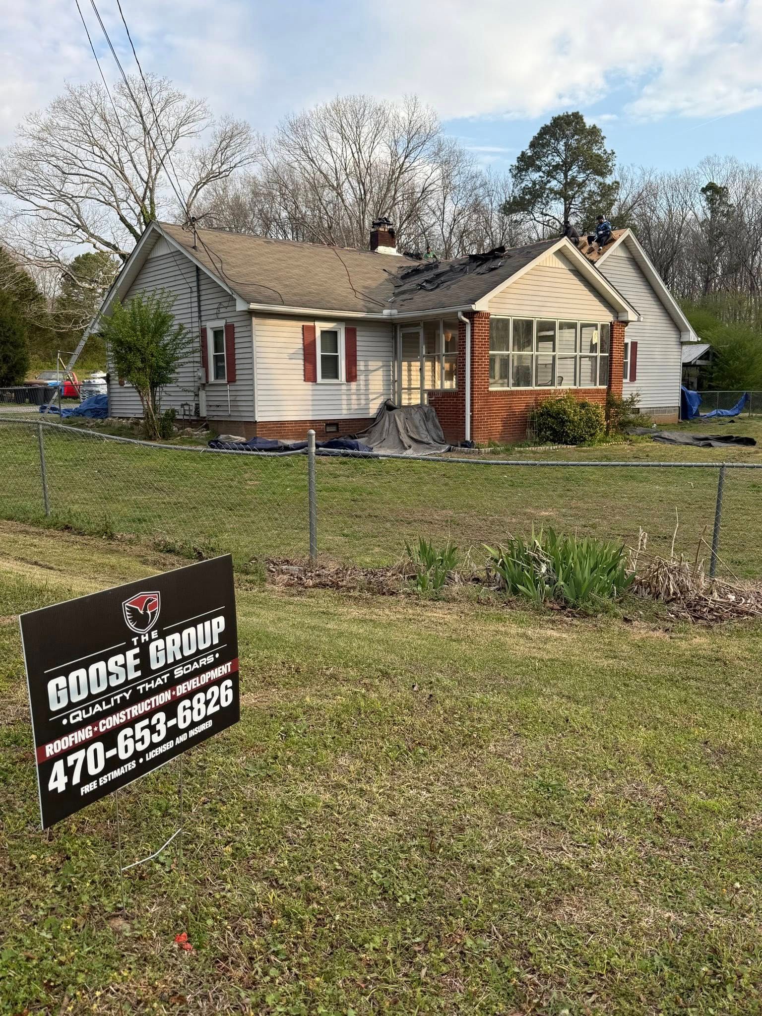 Single-story house with a yard and a real estate sign in front, under leafless trees.