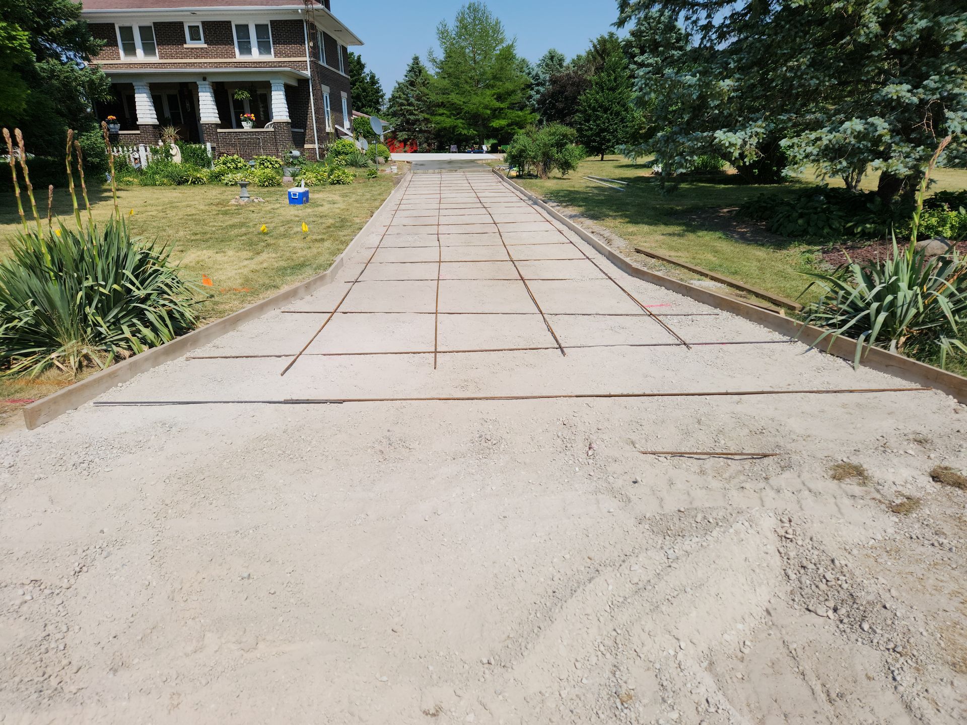 a driveway with a house in the background