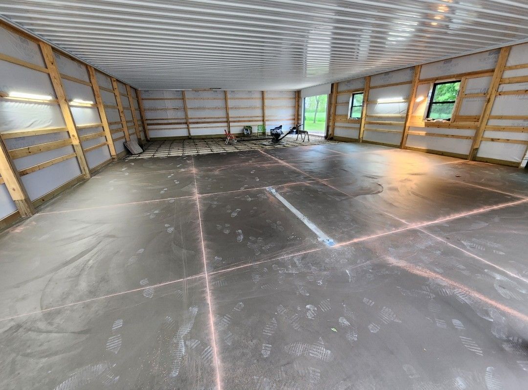 A large empty room with a concrete floor and wooden walls.