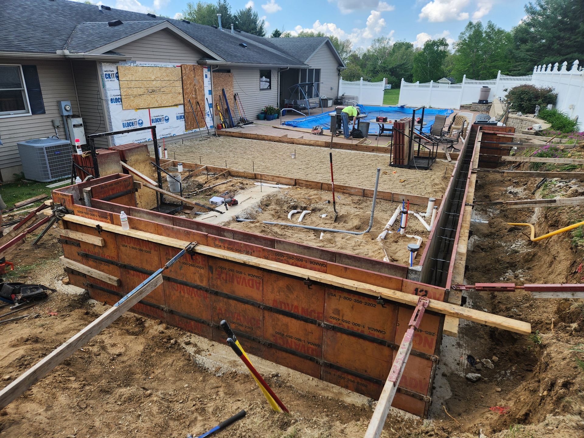 A concrete wall is being built in front of a house.