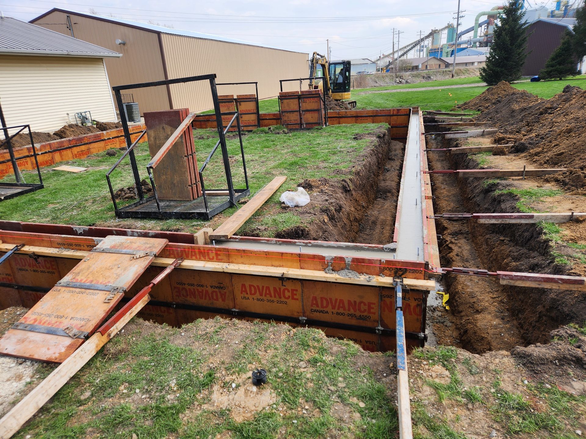 A concrete foundation is being built in a yard.