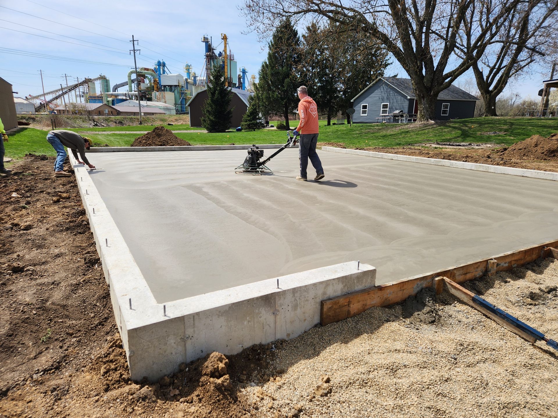 A man is using a machine to smooth concrete on a construction site.