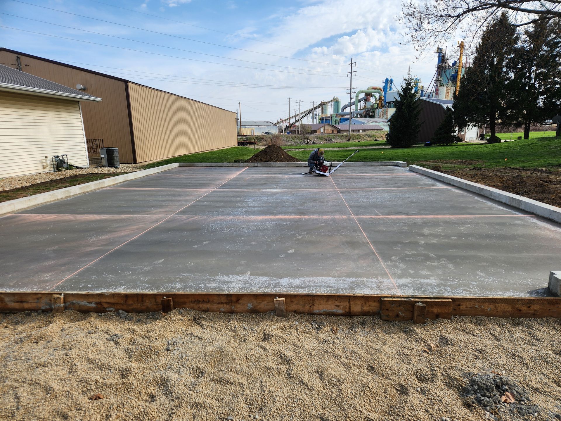 A man is working on a concrete floor in front of a building.