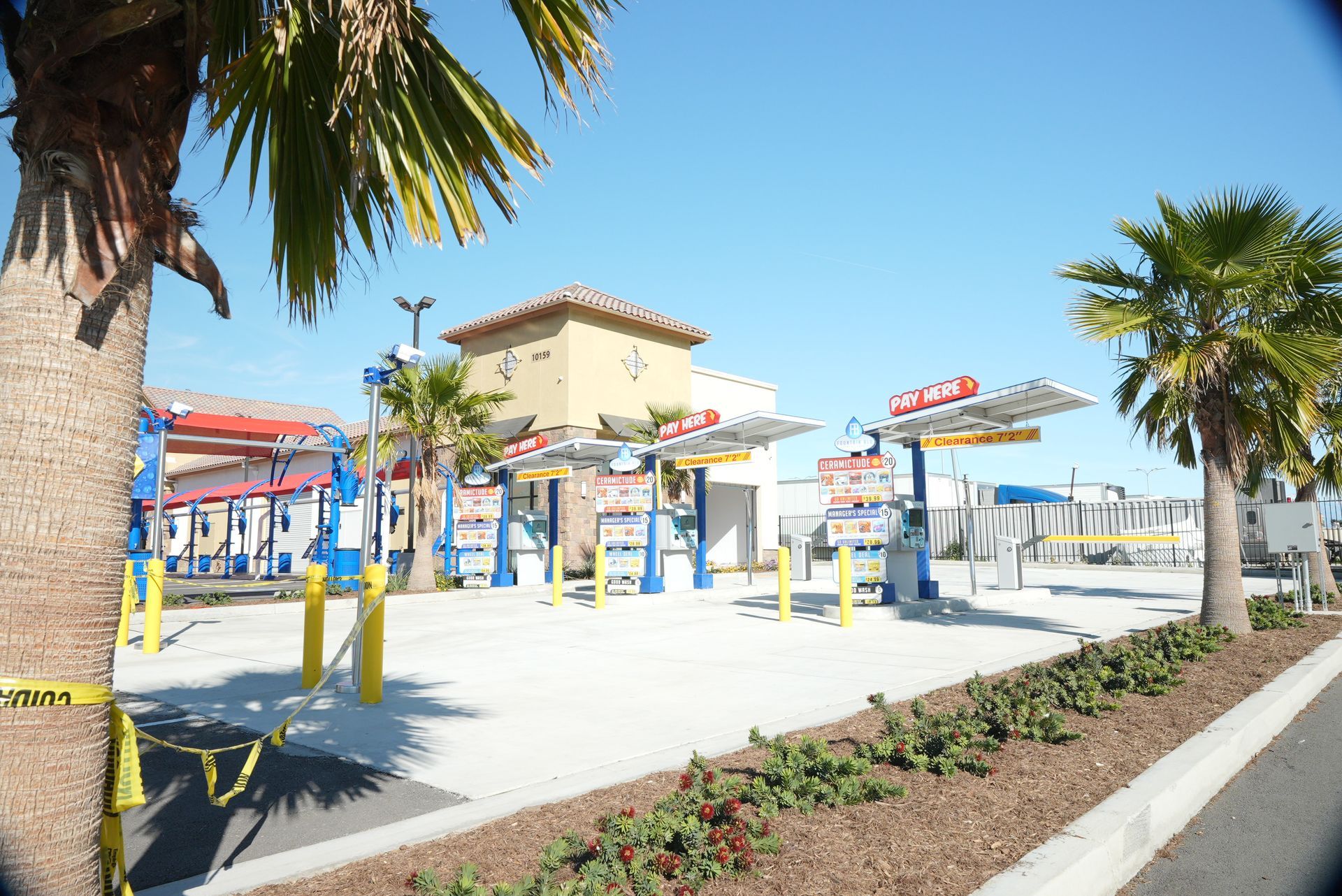 A car wash with a palm tree in the foreground