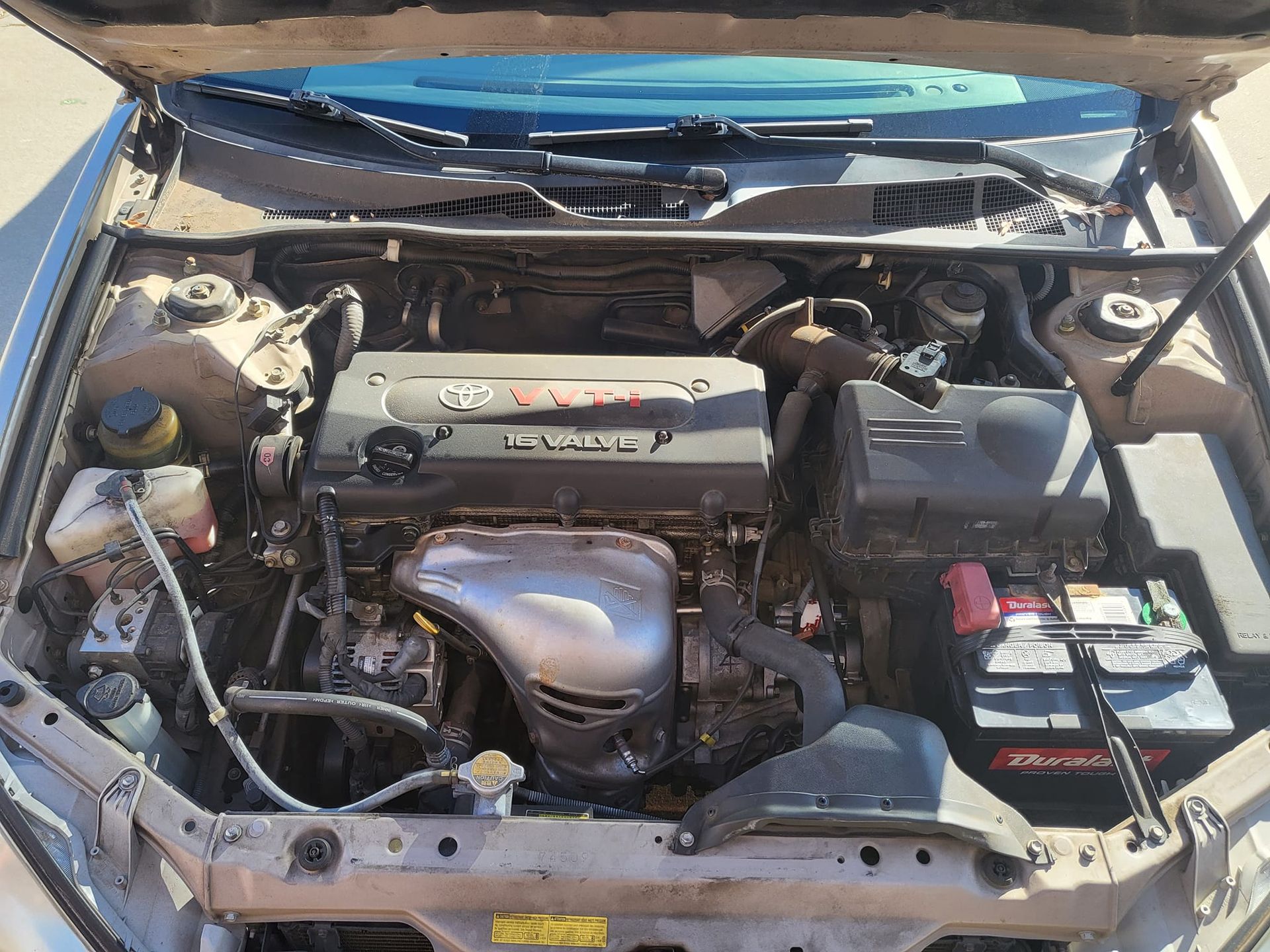 The engine of a car is shown with the hood open.