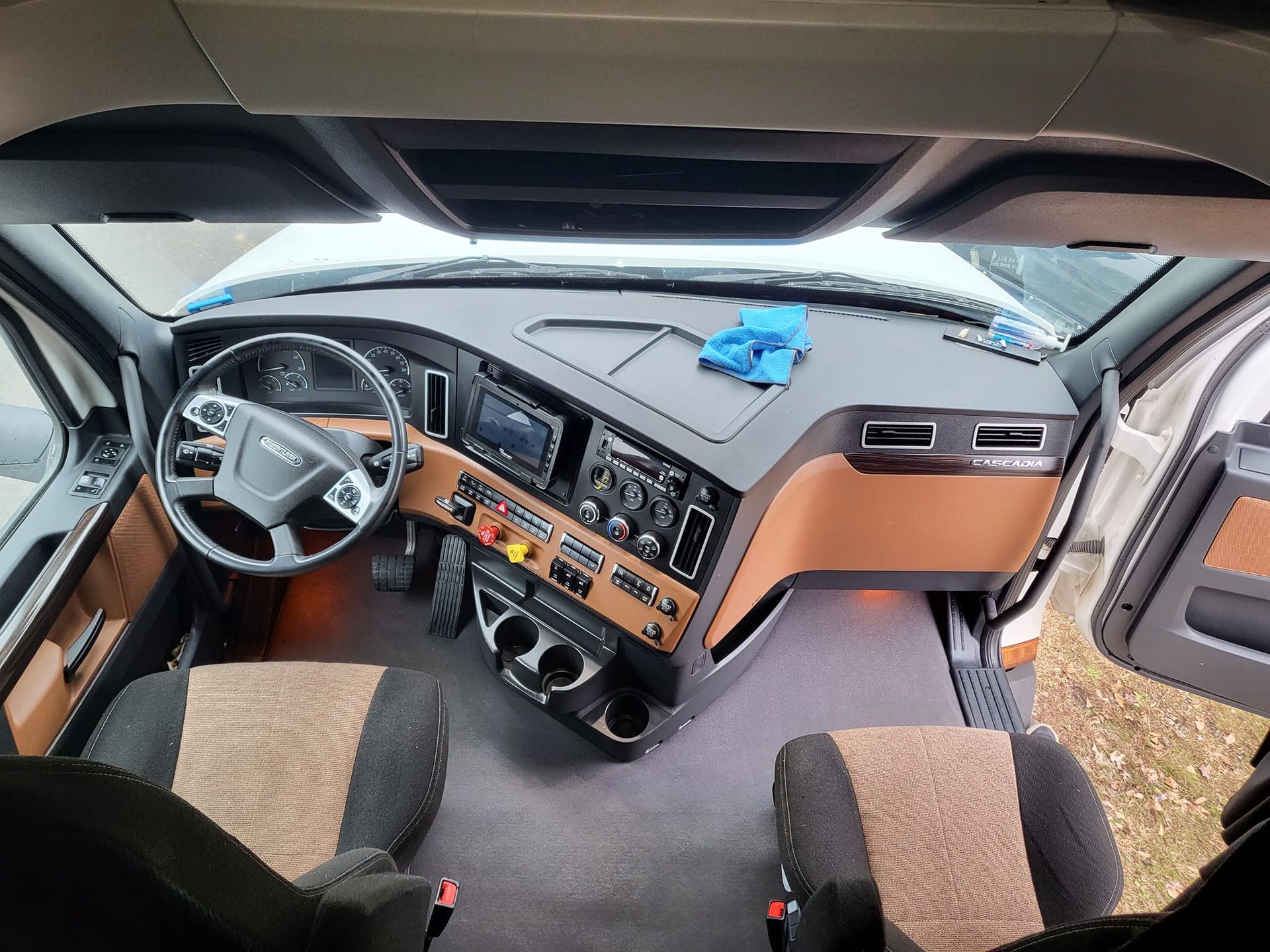 The interior of a truck with a steering wheel and dashboard.