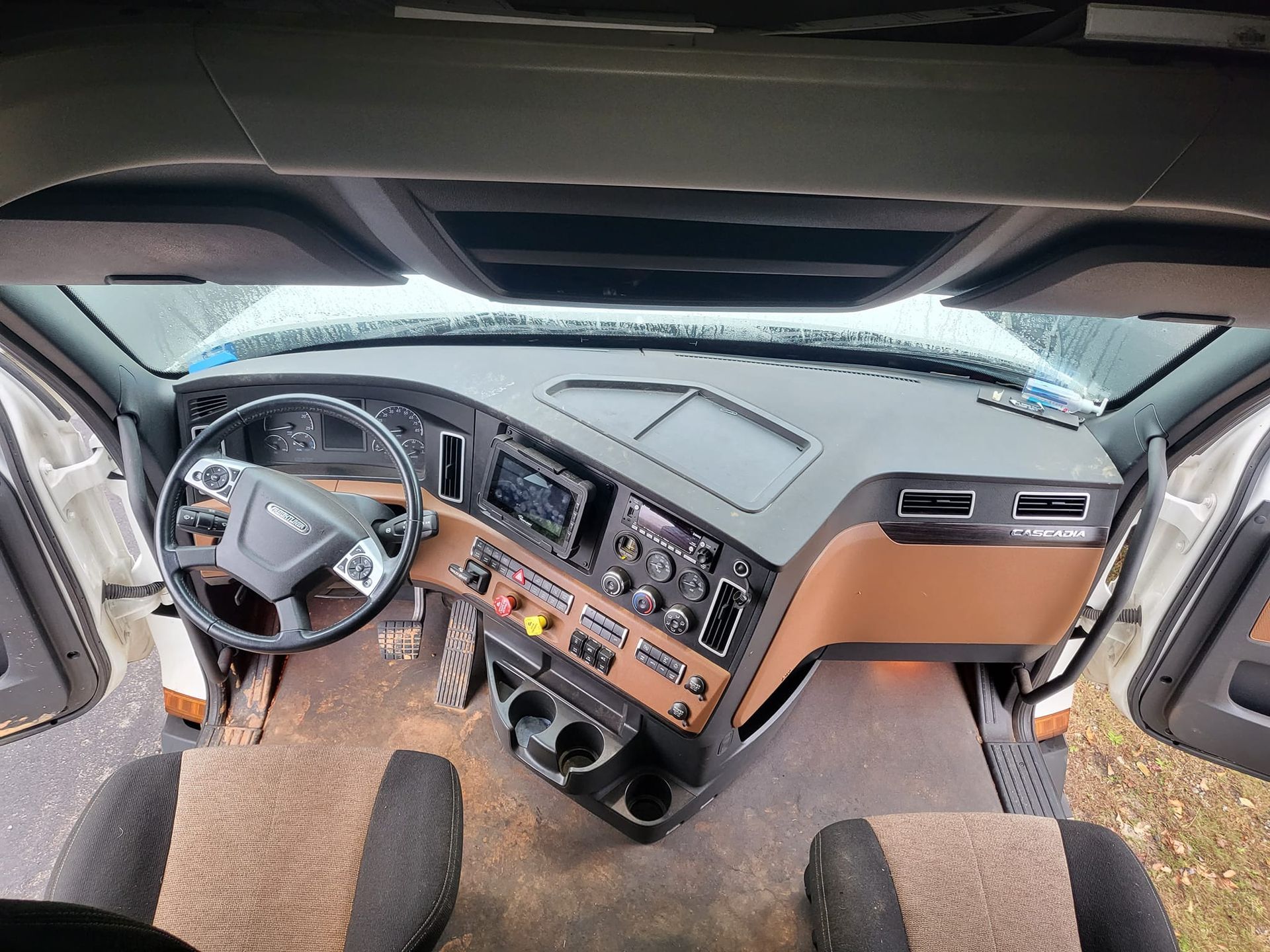 The inside of a truck with a steering wheel and dashboard.