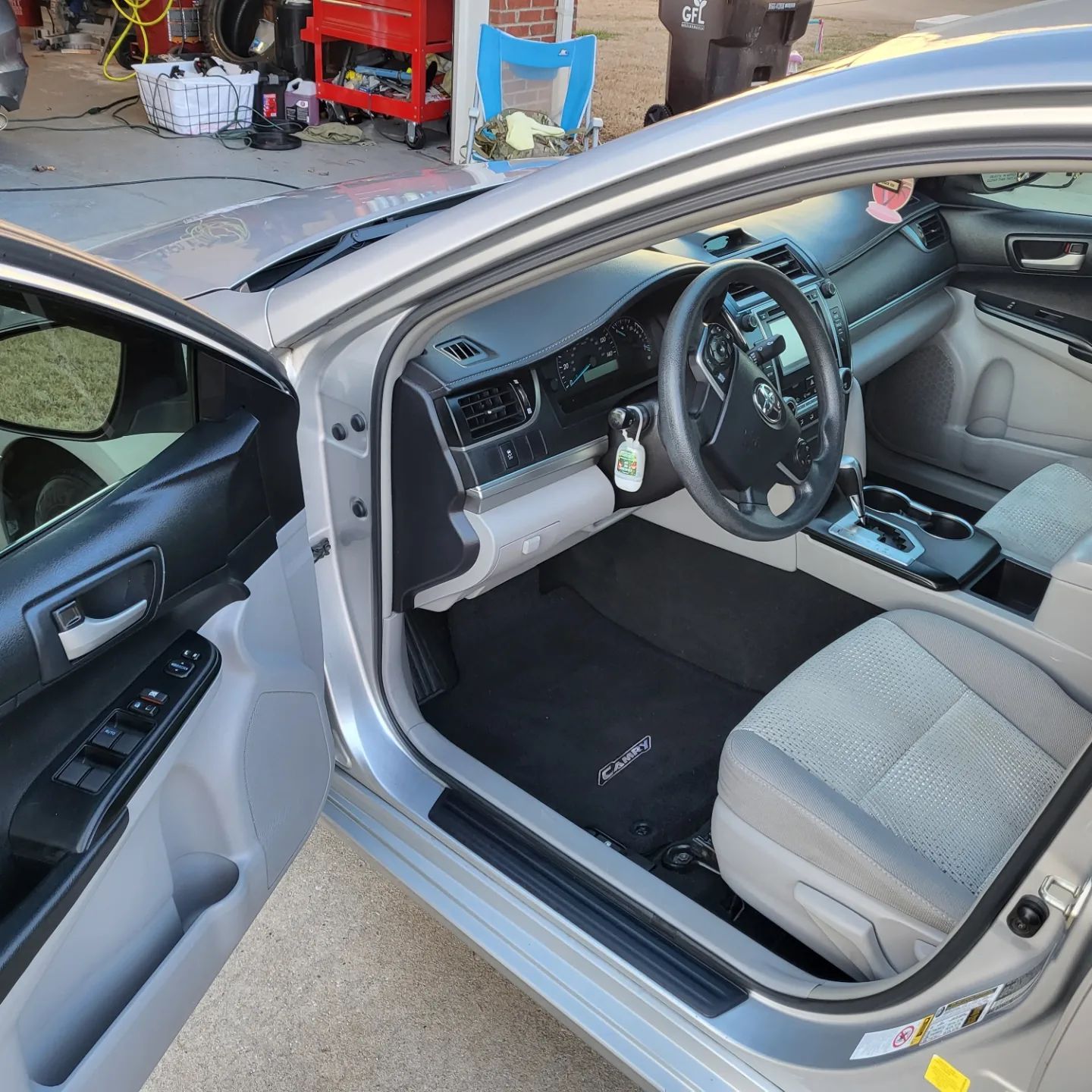 The inside of a silver car with the door open