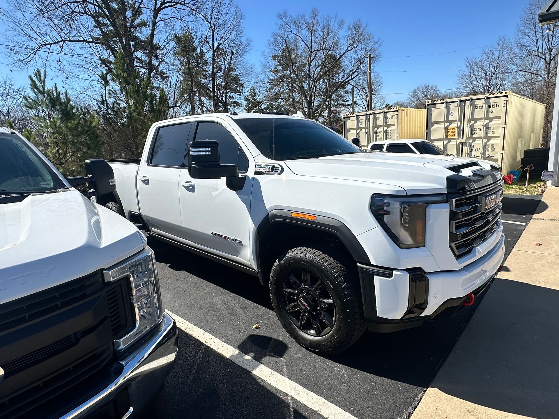 White GMC truck parked outdoors on a sunny day.