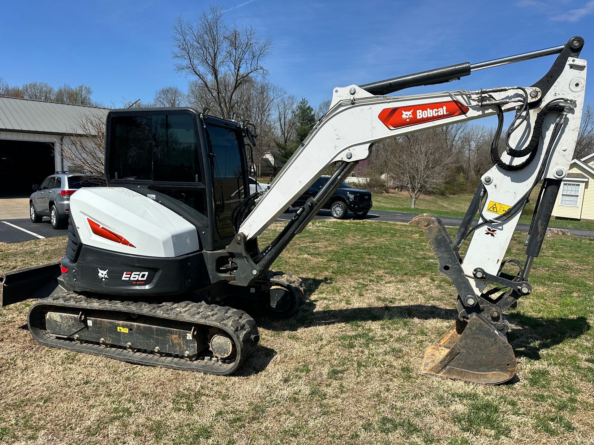 Bobcat E50 excavator on grass, with a black cabin and a bucket.