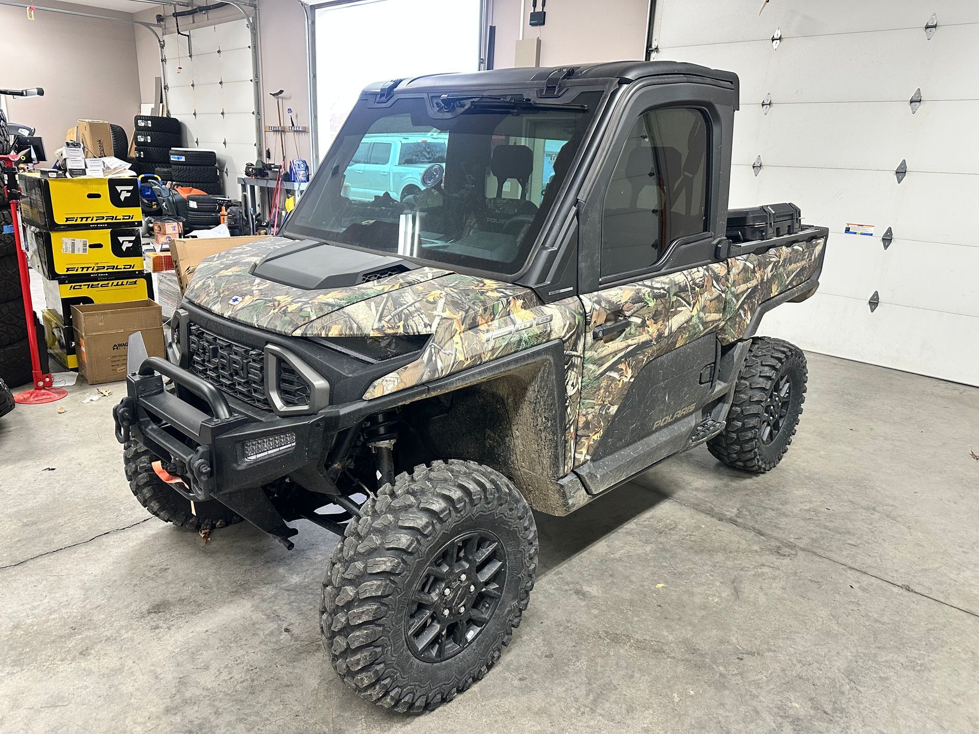 Camouflage UTV with black accents in a garage.