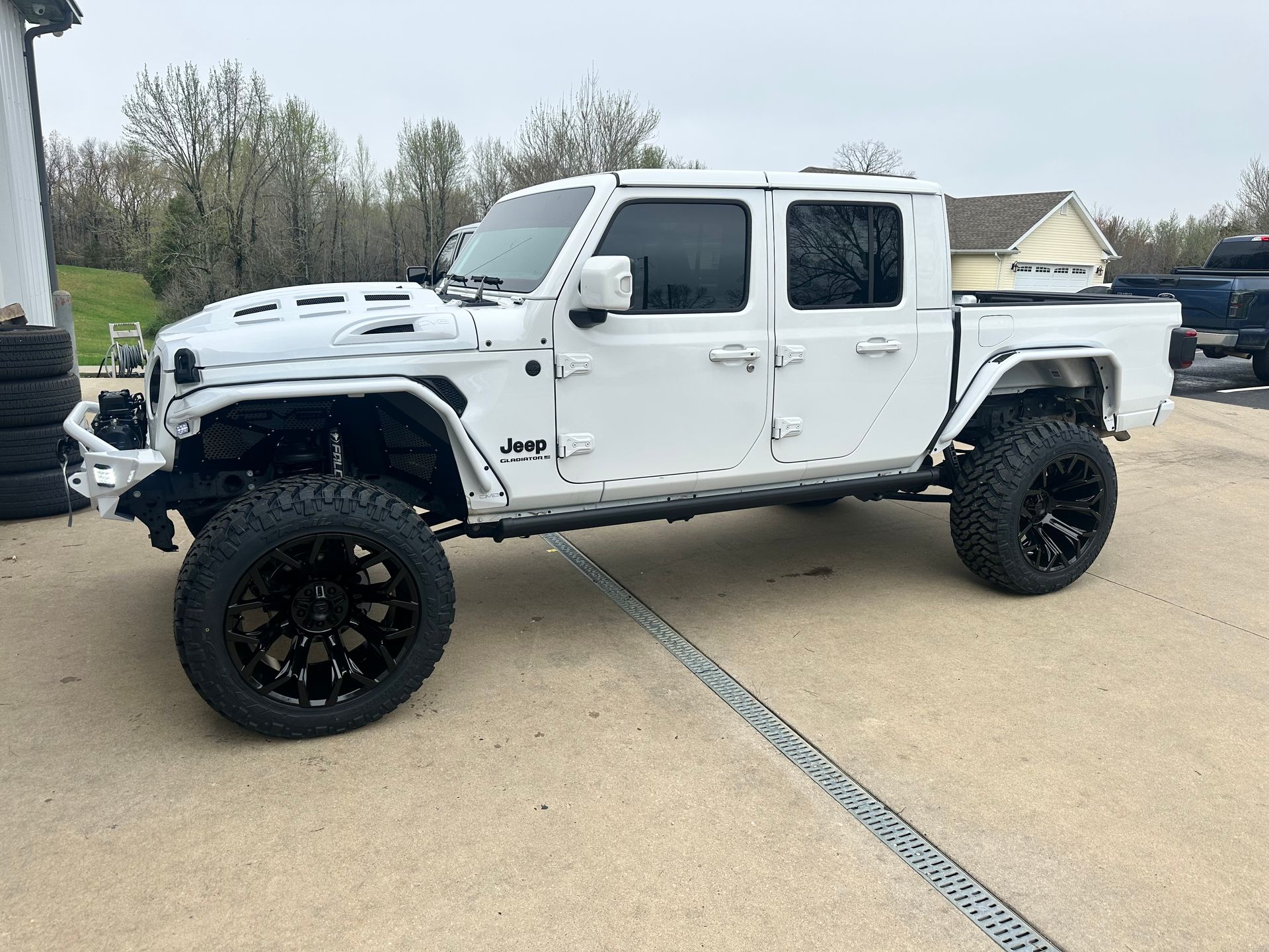 White lifted Jeep Gladiator with black wheels.