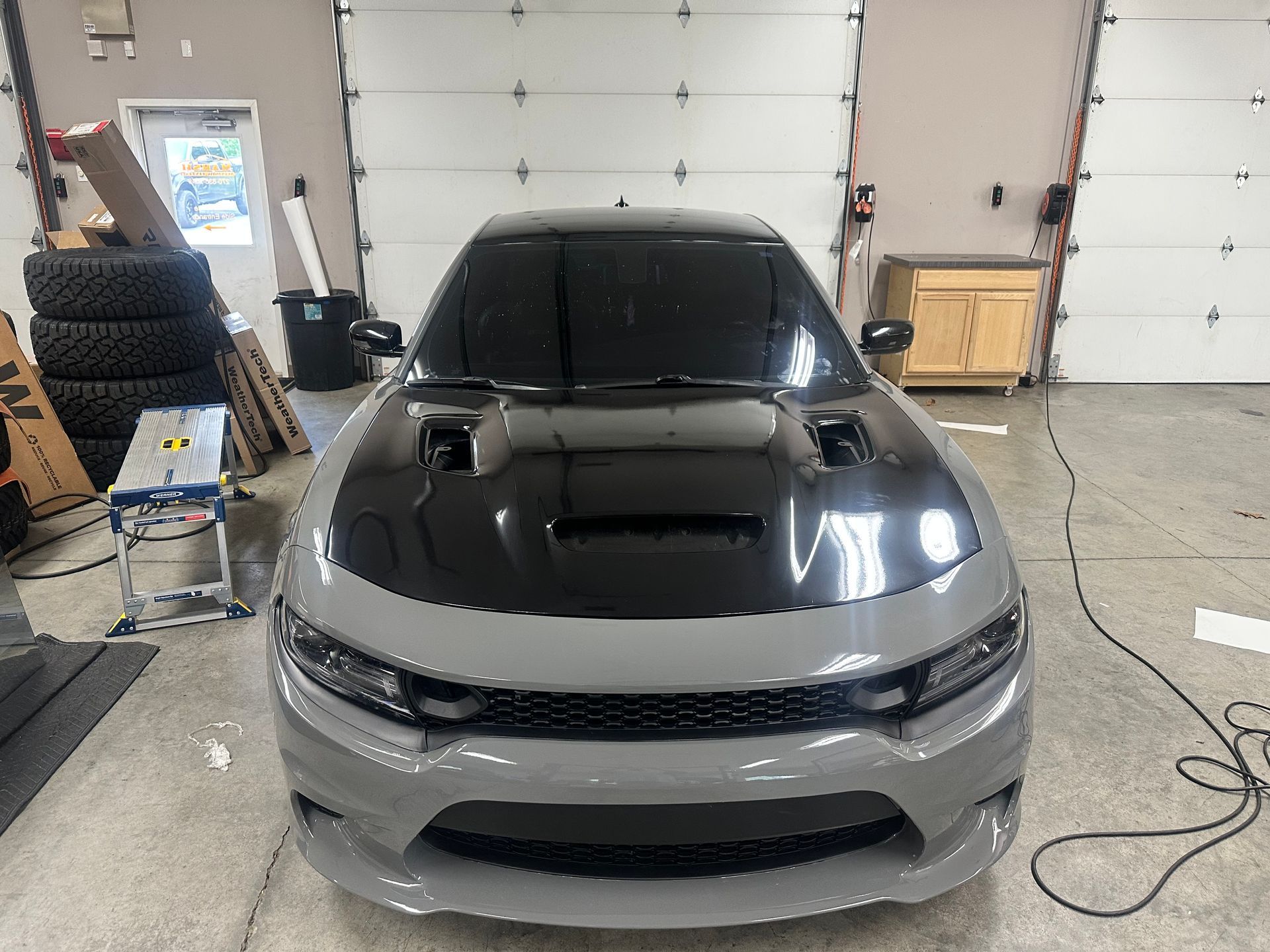 Gray and black Dodge Charger in a garage.