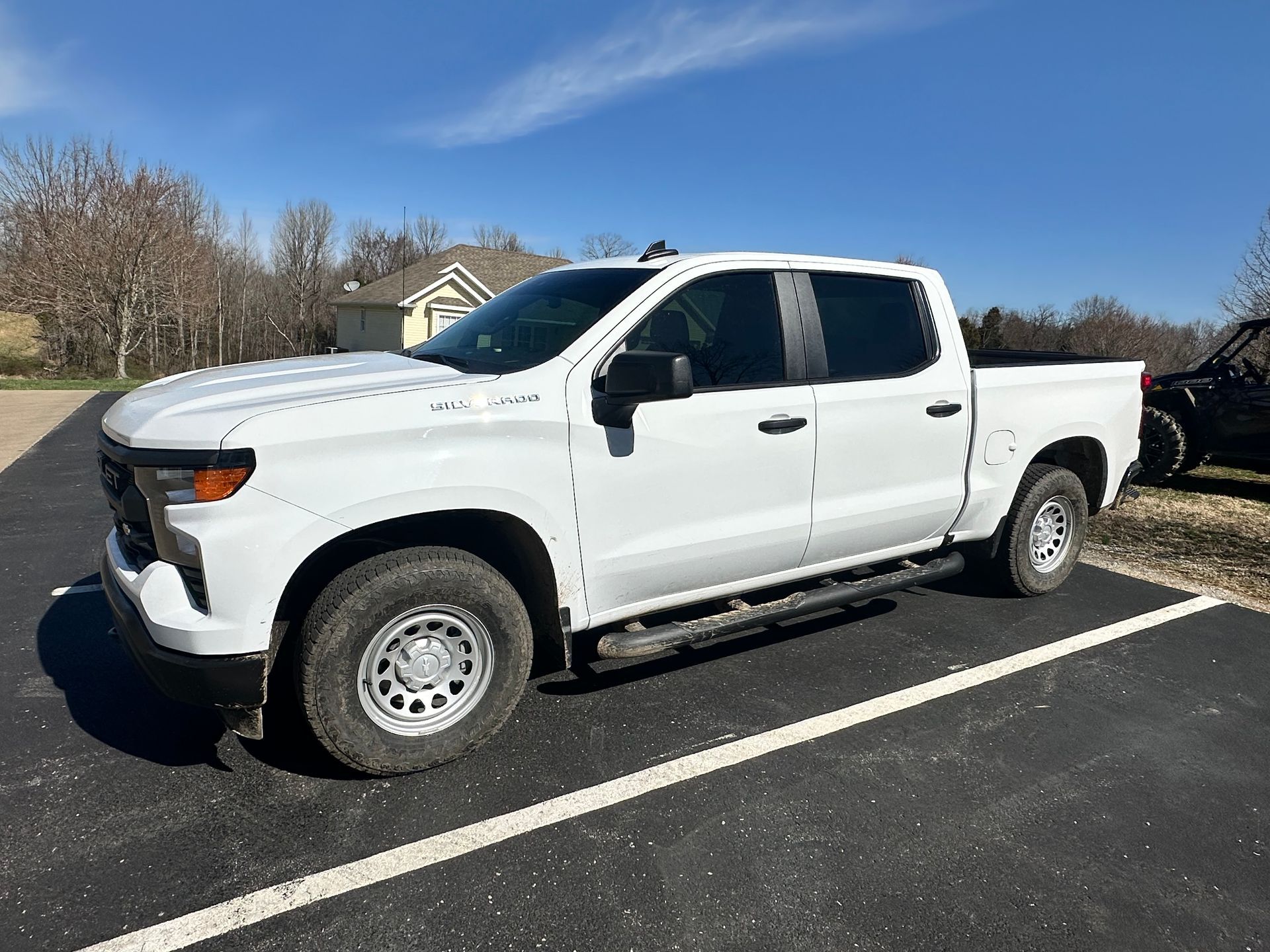 White Chevy pickup truck parked outside on a sunny day.