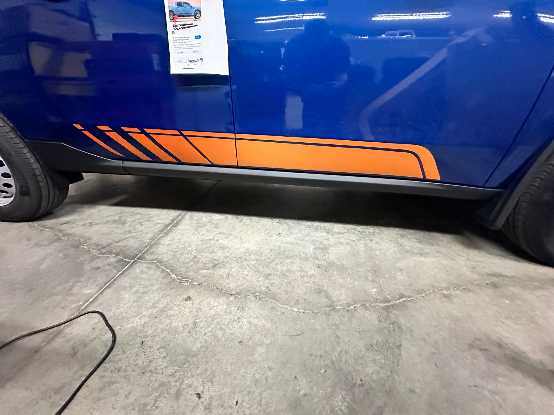 Blue car side with orange stripe detail.