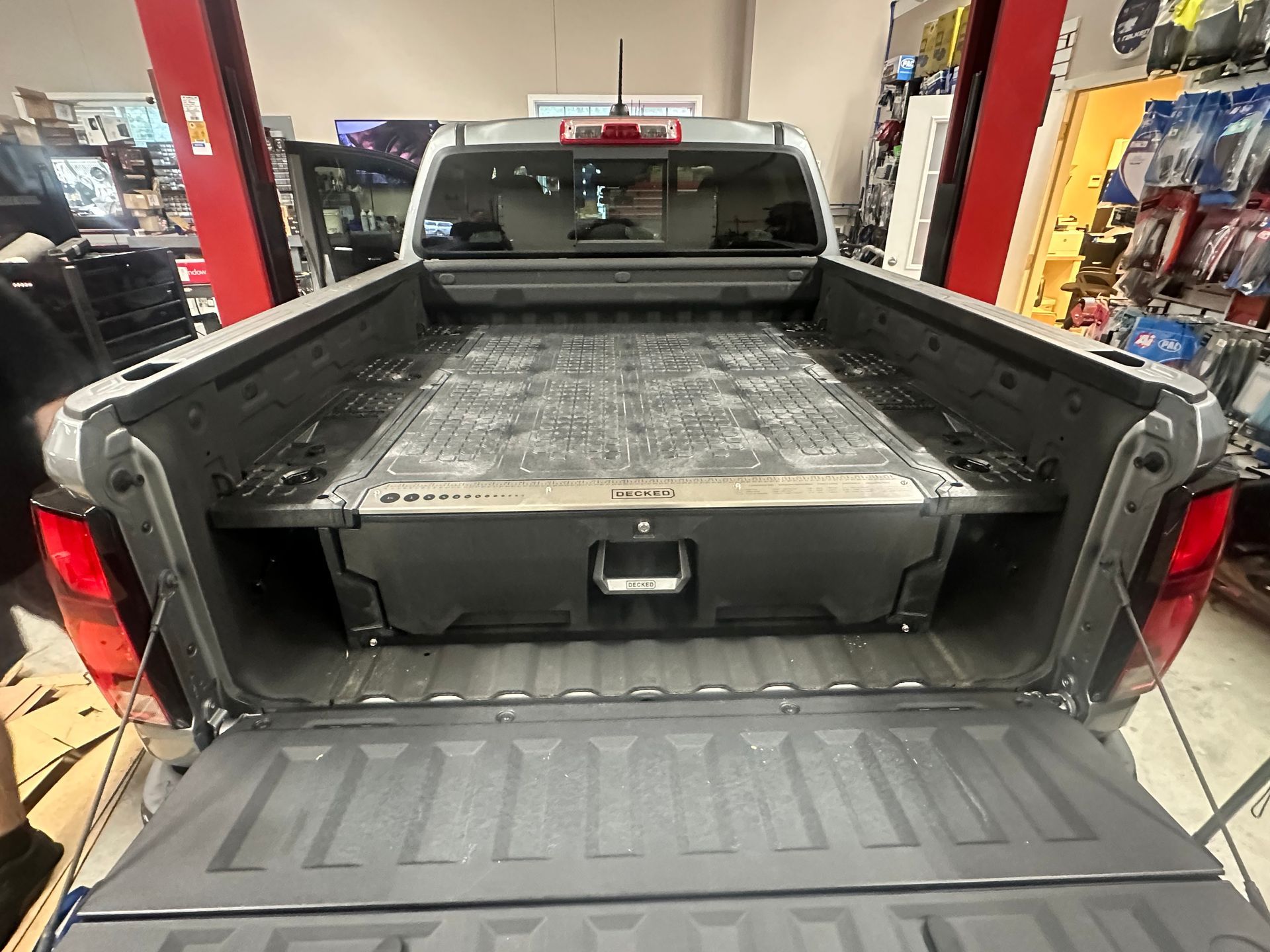 Gray truck bed with a black storage system installed.