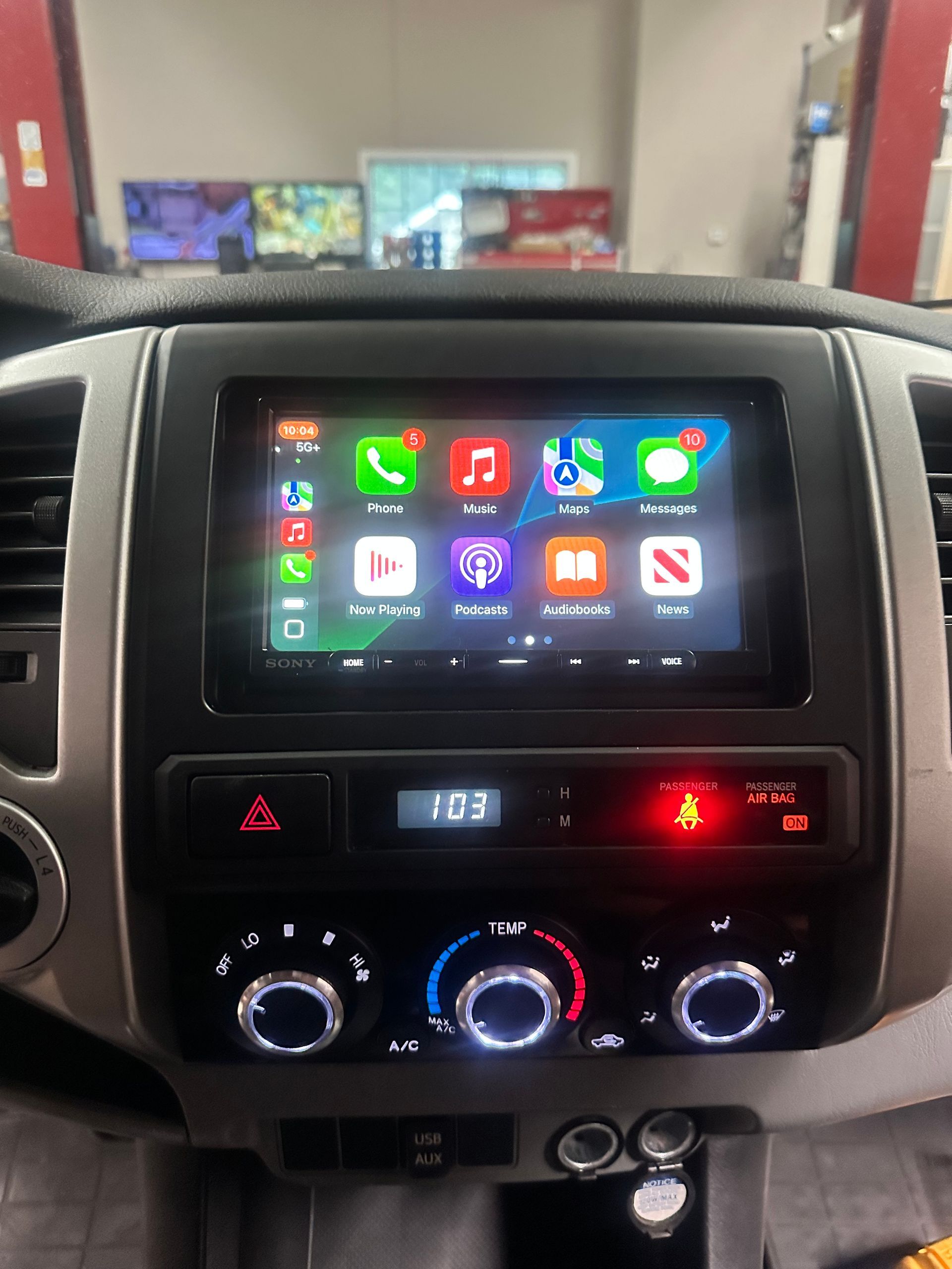 Car dashboard with a touchscreen displaying app icons, including phone, music, and maps.
