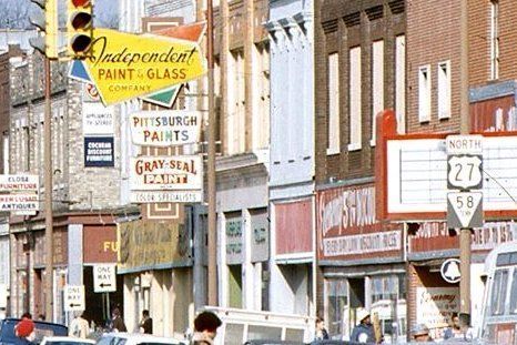 Row of old storefronts with signs for businesses like 