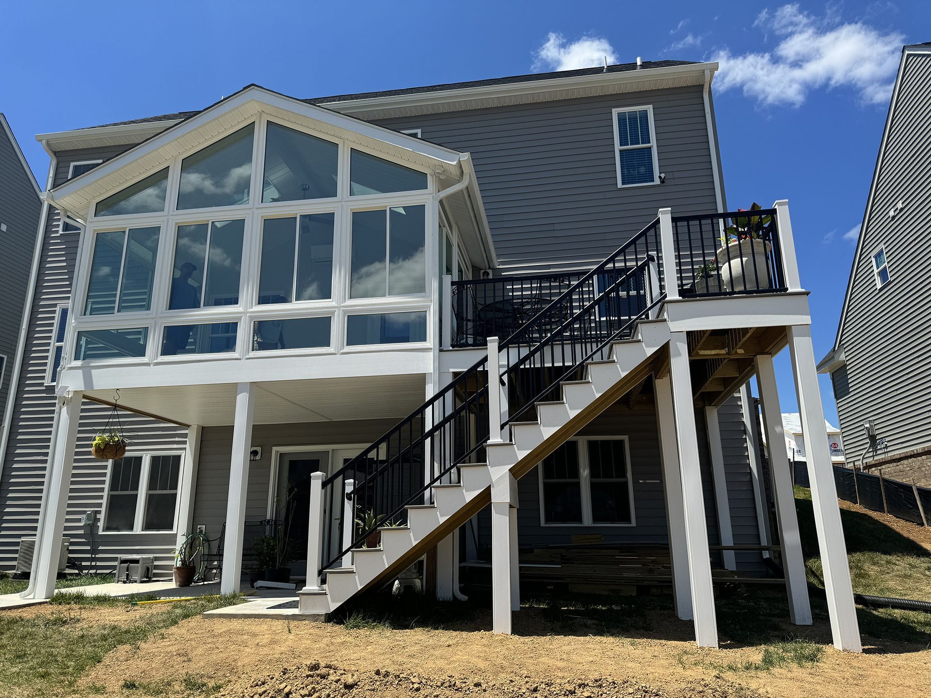 The back of a house with a sunroom and stairs.