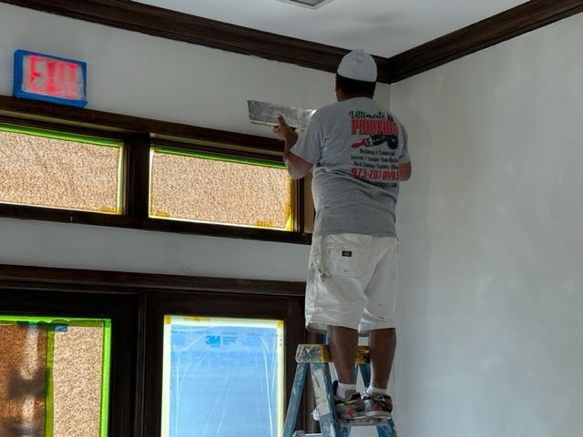 Man painting the wall above the exit door